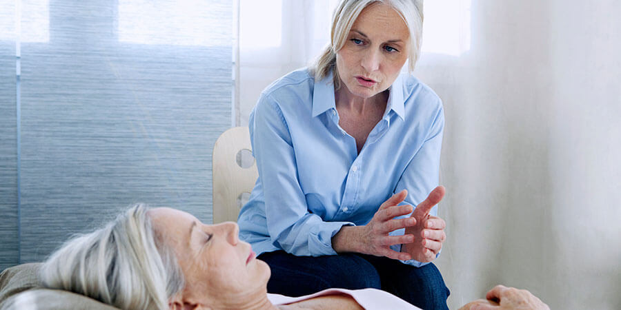 Hypnose Oerlikon | Frau liegt auf Couch, Therapeutin sitzt im Hintergrund