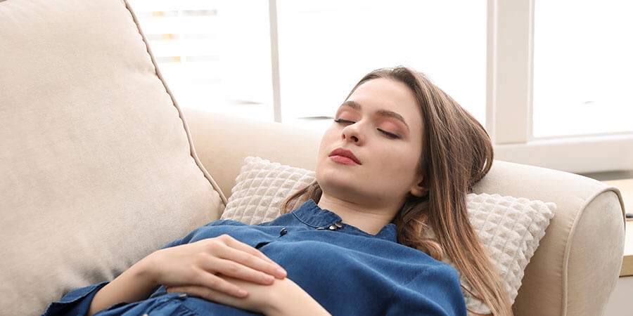 Hypnose Aarau | Frau liegt auf Couch mit geschlossenen Augen.