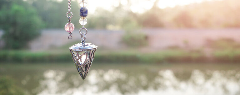 Hypnose Reinach | Pendel mit Kristallen, Teich im Hintergrund