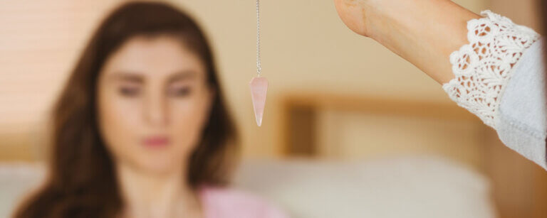 Hypnose Limmattal | Kristallpendel im Hintergrund sitzende Frau mit geschlossenen Augen