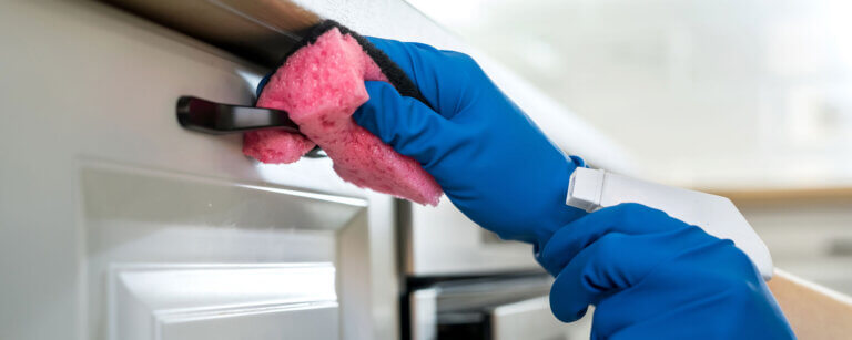 Hauswartung in Affoltern am Albis | Person putzt Küchentür mit Schwamm im Handschuh