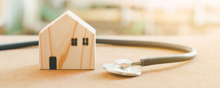 Hauswartung in Basel | Holzmodell eines Hauses mit Stethoskop