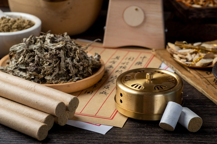 Traditionelle Chinesische Medizin in Frauenfeld | Nahaufnahme verschiedener Kräuter, Schriftrollen, Holzrollen und bronzener Kräuterkessel, Utensilien für TCM