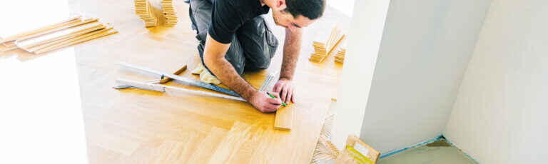 Umbau und Renovationen in Baden | Handwerker bei der Arbeit- Parkett verlegen