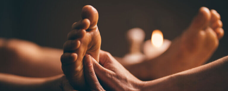 Shiatsu in Zürich | Fuß eines Patienten wird bei Kerzenschein manuell behandelt