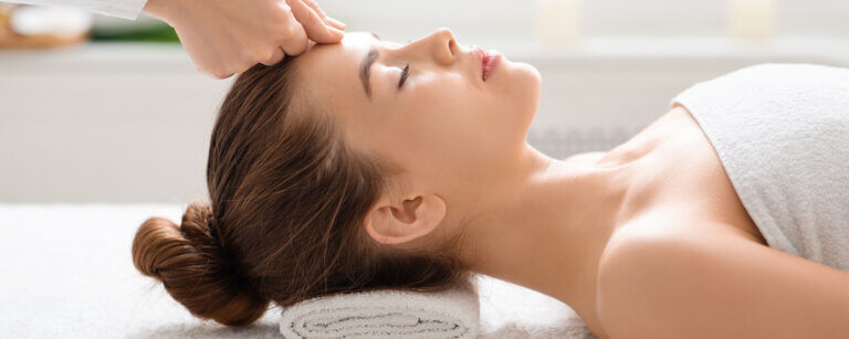 Shiatsu in Luzern | Frau wird liegend am Kopf manuell behandelt